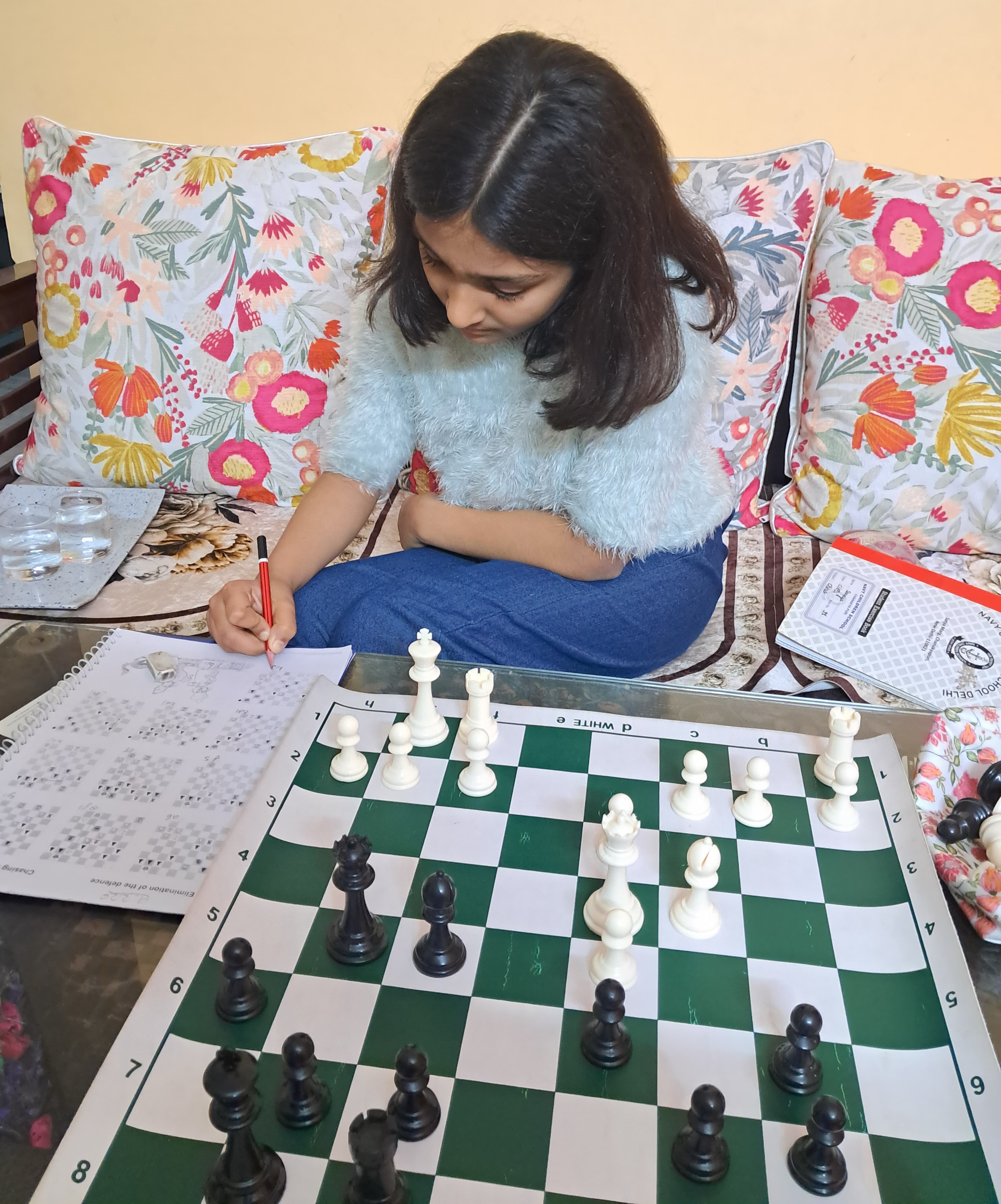 Student recording moves during chess competition