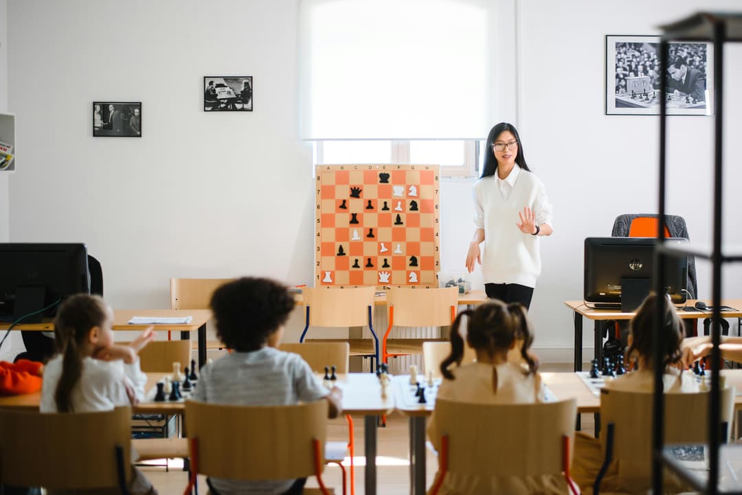 Chess coach guiding children in a focused learning environment